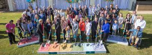 Colorful sand with groups holding shovels