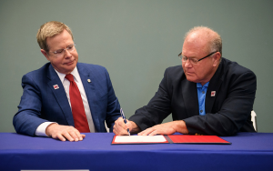 Chancellor and man signing papers