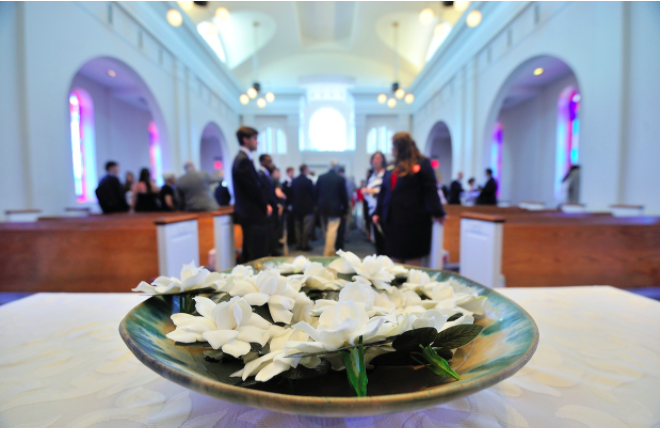 Gardenias In the Chapel in a bowl, and people gathered in pews