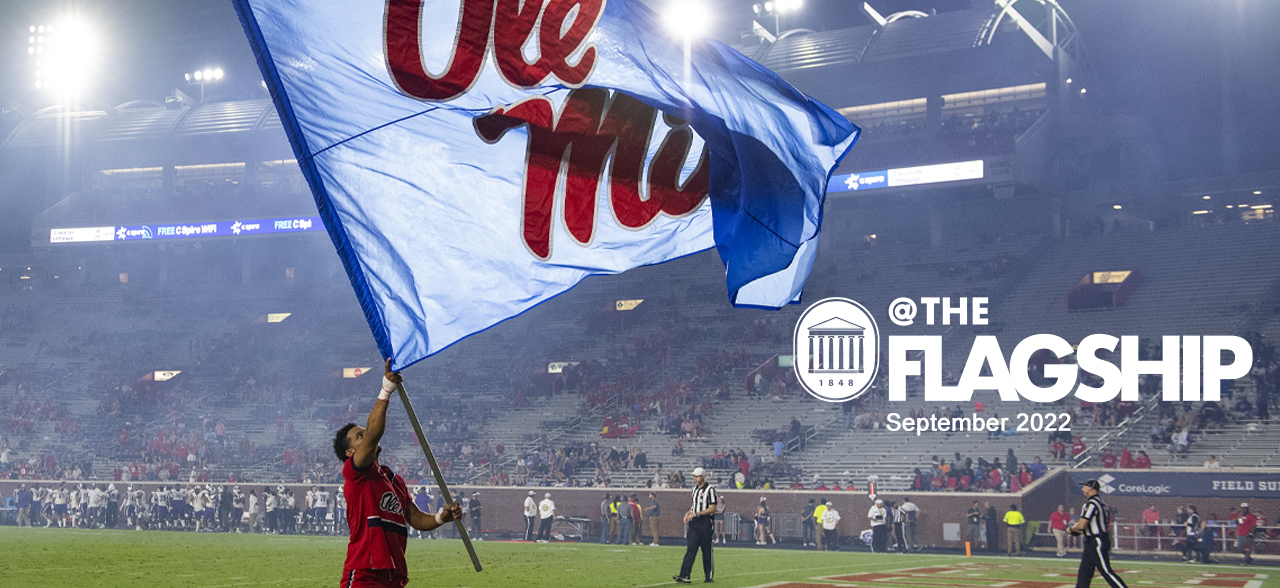 A male cheerleader waves the Ole Miss flag at a football game, @The Flagship, September 2022